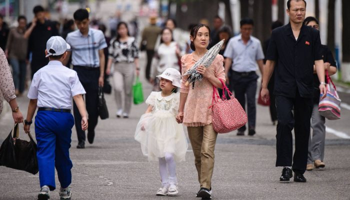 Pedestres caminham por uma rua em Pyongyang, na Coreia do Norte
             -       
        KIM WON JIN/AFP