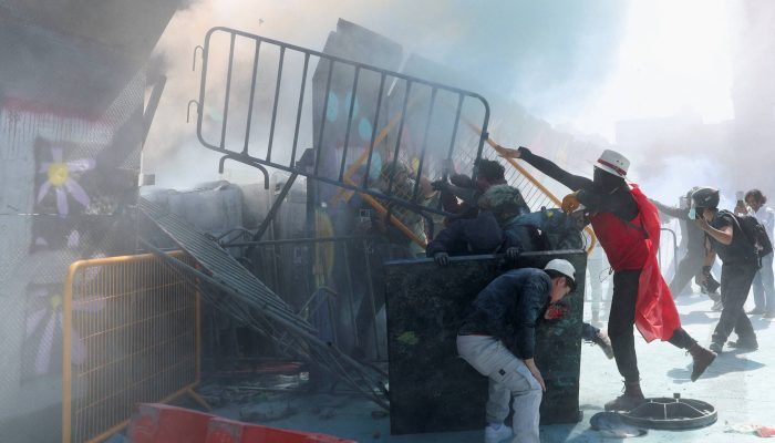 Manifestantes em barricadas no Palácio Nacional na Cidade do México. Milhares foram às ruas contra medidas de segurança do governo federal mexicano

             -       
        Luis Cortes/Reuters