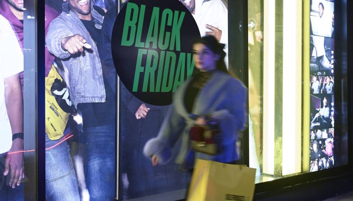 Uma mulher passa por uma loja com propaganda da Black Friday, em Londres
             -       
        Jaimi Joy - 23.nov.2025/Reuters