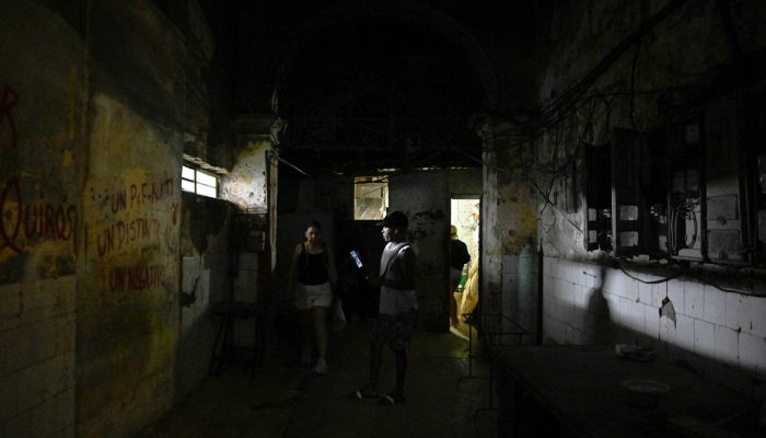 Pessoas caminham por um corredor após o restabelecimento da energia, depois de um colapso parcial da rede elétrica, em Havana
             -       
        Norlys Perez - 3.dez.25/Reuters