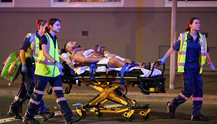 Equipe de resgate transportam um homem para uma ambulância após ataque na praia de Bondi, em Sydney
             -       
        Saeed Khan/AFP