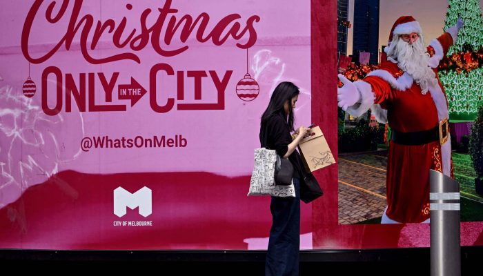 Mulher com sacolas de compras no distrito comercial central de Melbourne, na Austrália 
             -       
        William West/AFP