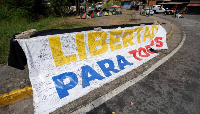 Uma faixa com os dizeres "Liberdade para todos" é exibida em frente à prisão El Rodeo I em Guatire, estado de Miranda, Venezuela
             -       
        Pedro Mattey - 20.fev.26/AFP
