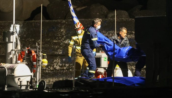 1 de 1Bombeiros carregam corpos após o naufrágio de um barco de migrantes perto do porto de Ierapetra, na ilha de Creta — Foto: COSTAS METAXAKIS / AFP