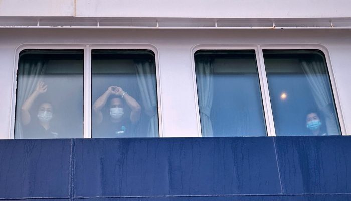 1 de 4Passageiros observam enquanto outras pessoas desembarcam do navio de cruzeiro MV Hondius — Foto: Associated Press